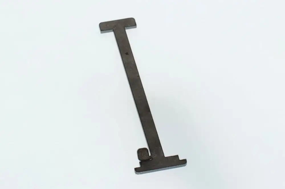 Dunkles Metallteil mit einer langen, flachen Form und einer seitlichen Aussparung, hergestellt von Bosch.